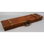 A leather gun case with double belt strap clasps.