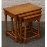 A nest of three oak occasional tables raised on turned supports.