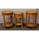 A pair of hardwood two tier lamp tables and a similar drum table.