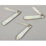 Three silver folding fruit knives with mother of pearl scales.