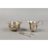 A silver sugar bowl and cream jug, assayed Birmingham 1931 along with a pair of silver sugar