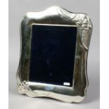 A large sterling silver mounted eizel photograph frame embossed with flowers and with beaded rim,