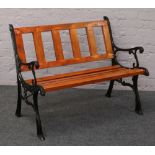A two seat garden bench with painted cast iron ends.