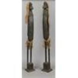 A pair of carved African softwood figures with natural fibre decoration.