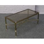 A brass and smoked glass coffee table with reeded supports.