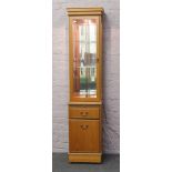 A Quinn furniture teak slender display cabinet with rotating interior.