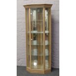 A limed oak effect corner display unit with mirrored back.