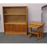 A Gibbs teak bookcase with cupboard base along with a teak nest of three tables.