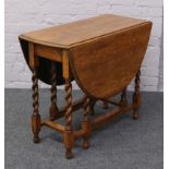 An oak drop leaf table with barleytwist supports.