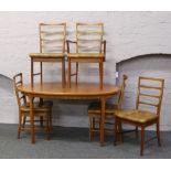 A McIntosh teak oval extending dining table and five chairs to include one carver.