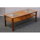 A teak g plan two tier coffee table with glass tops and double sided drawers.