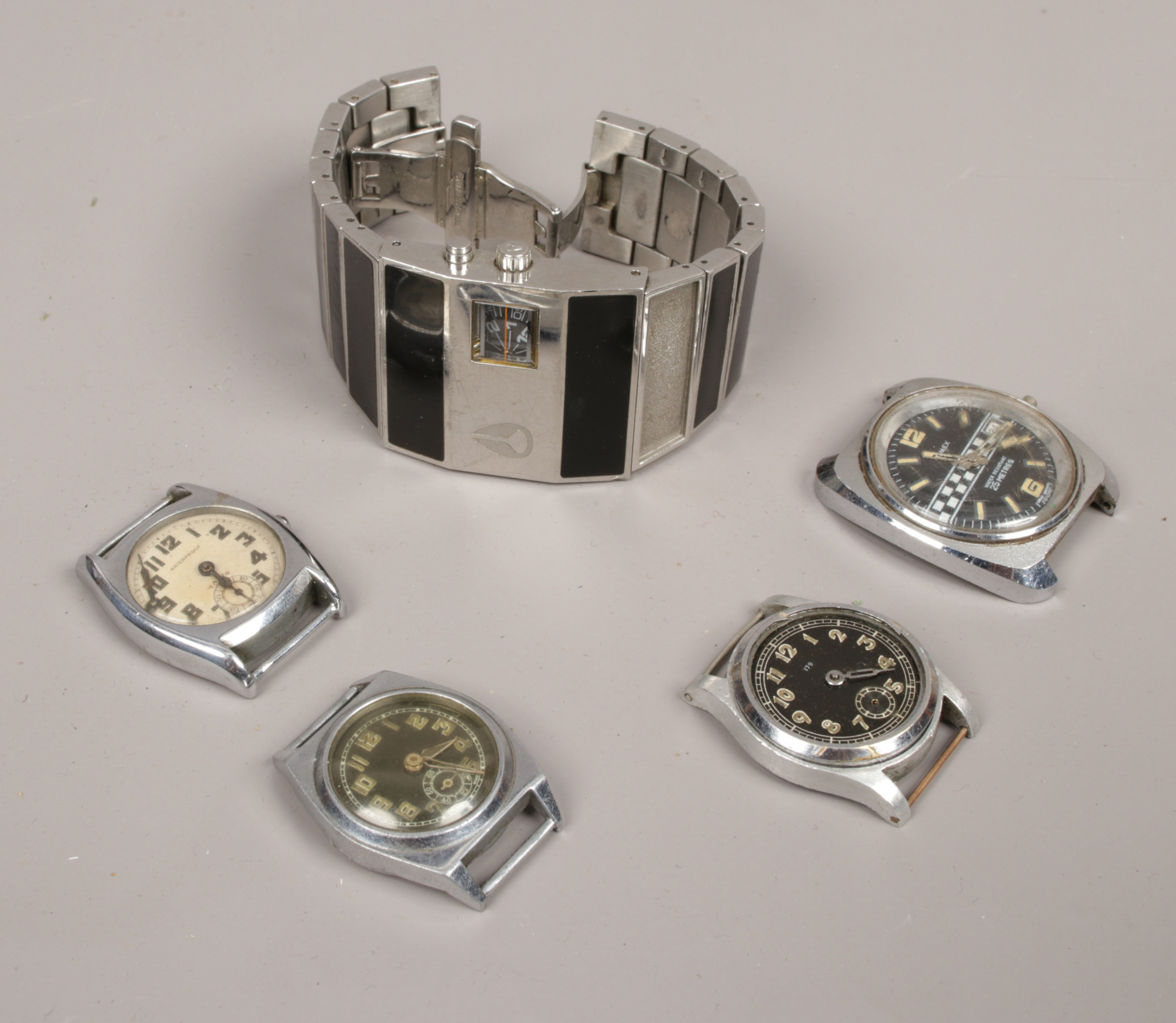 Four watch heads and one wristwatch to include Timex Ralley, Nixon Rotolog wristwatch examples etc.