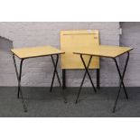 Three schools desks on folding steel supports.