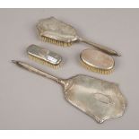 A silver dressing table brush and mirror set along with two smaller silver brushes.