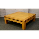 Heal light oak coffee table of large proportions raised on tapering square supports.