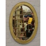 A pewter framed oval mirror with bevelled glass later gold painted.