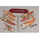 A collection of sheathed knives to include bone carved hardwood handles.