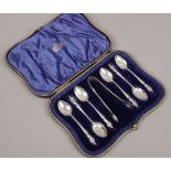 A cased set of six silver apostle spoons and sugar tongues, assayed Chester 1909 by Barker Bros,