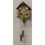 A West German musical cuckoo clock with pendulum and weights.