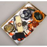 A tray of vintage celluloid and Bakelite buttons and jewellery.