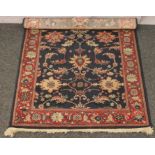 A red and blue ground wool rug with floral decoration 166cm x 121cm.