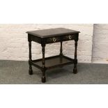 A carved oak two tier side table with two drawers.Condition report intended as a guide only.Chip