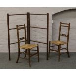 A mahogany folding clothes horse along with a pair of oak rush seat chairs.