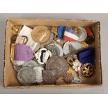 A box of medals and enamel badges.