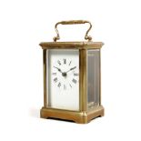 A French brass and glass carriage clock with Roman numeral markers.