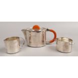 An Art Deco silver plated three part tea set, the teapot with phenolic butterscotch amber coloured