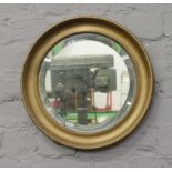 A circular gilt framed bevel edge wall mirror.