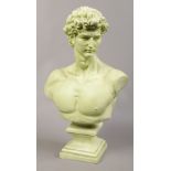 A painted green composite bust of David, raised on socle base.