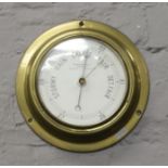 A wall mounted brass barometer by Dobbie McInnes Limited.