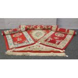 A Chinese red ground wool rug with floral decoration 204cm x 120cm along with two similar floor