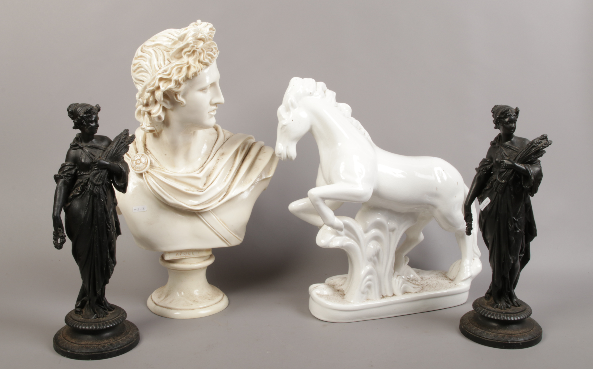 A group lot including a pair of spelter figures, composite bust of Apollo, ceramic rearing horse