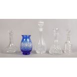 Four cut glass decanters along with a blue flash glass vase.