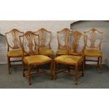 A set of 12 yew wood chairs to include two carvers with carved Wheatsheaf decoration to the backs.