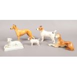Two Beswick models of Jack Russel terriers along with two seated grey hounds and one standing.