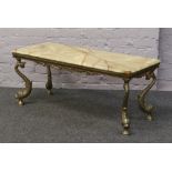 An onyx coffee table with gilt dolphin supports.
