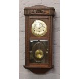 An Edwardian carved oak wall clock with Westminster chime in need of some restoration.