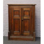 A Victorian mahogany corner cupboard with panelled doors and clack glass handle.