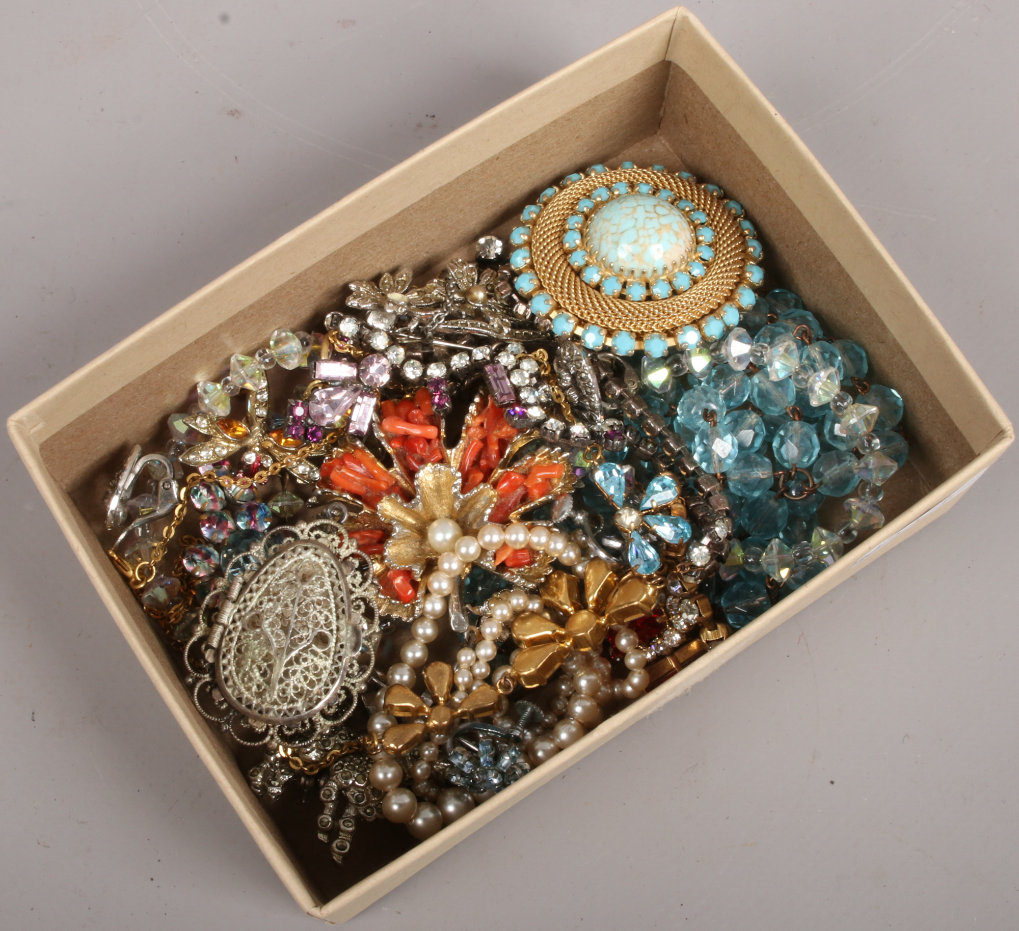 A collection of vintage costume jewellery to include coloured paste, coral brooch, marcasite,