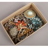 A collection of vintage costume jewellery to include coloured paste, coral brooch, marcasite,