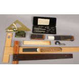 A collection of drawing equipment to include Riefler cased compass set, folding rulers, set squares,
