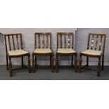 A set of four oak dining chairs raised on turned supports.