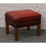 A red leather foot stool.