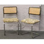 A pair of chrome chairs with bergere back rests and upholstered seats.