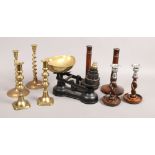 A set of iron and brass kitchen scales and weights, two pairs of oak candlesticks and two pairs of