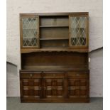 A carved, panelled and lead glazed oak dresser.