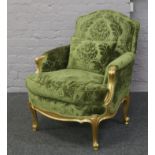 A French gilt arm chair with green floral upholstery.